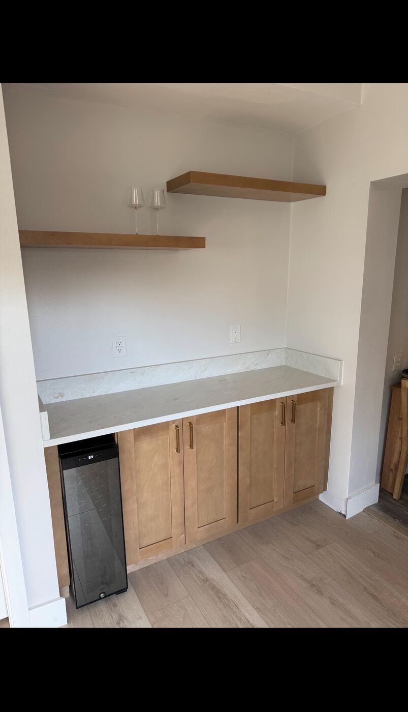 Bar nook with floating wood shelves and marble countertop