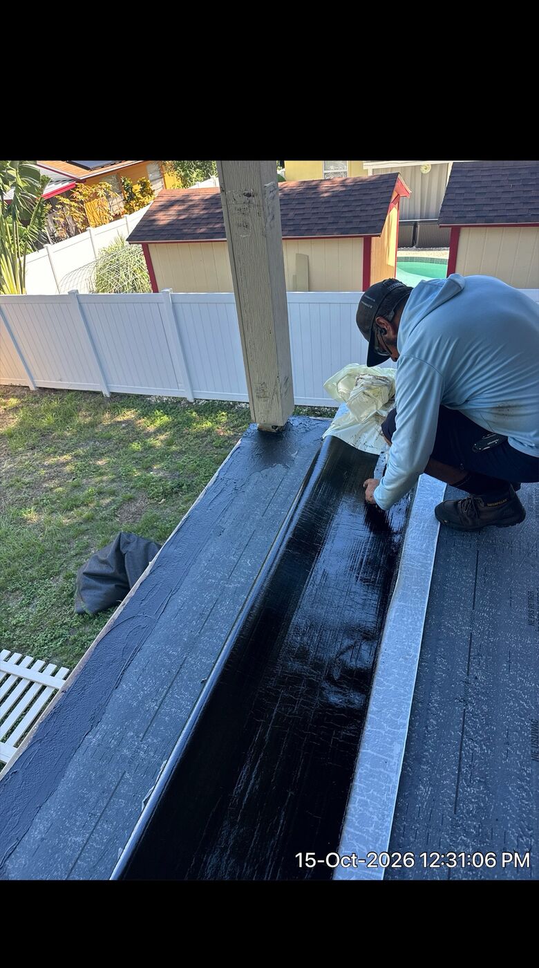 Worker applying waterproof membrane on exterior edge